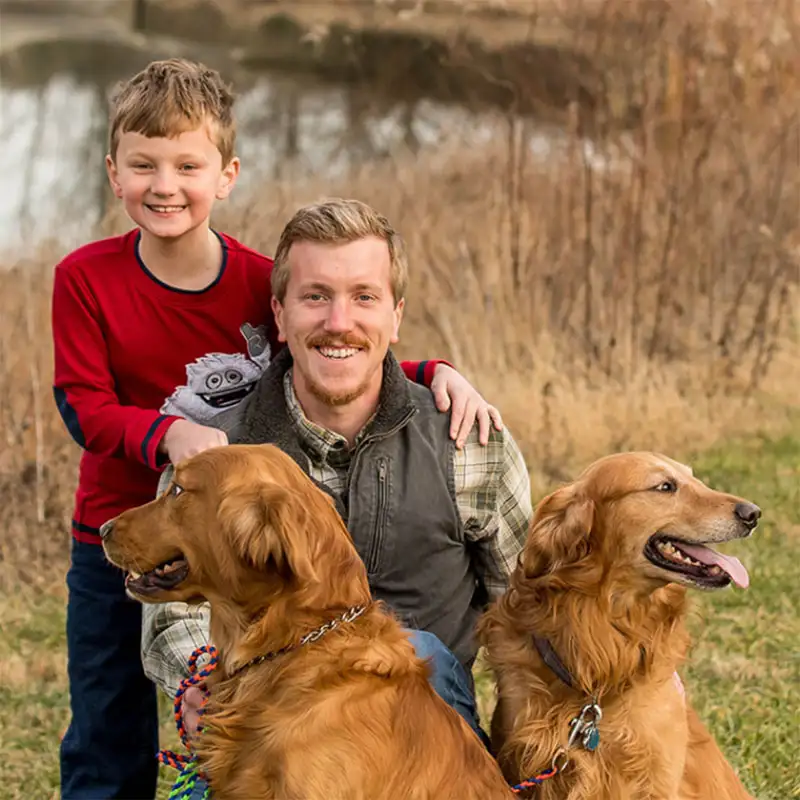 AJ Brooks with son and two dogs posing for photo